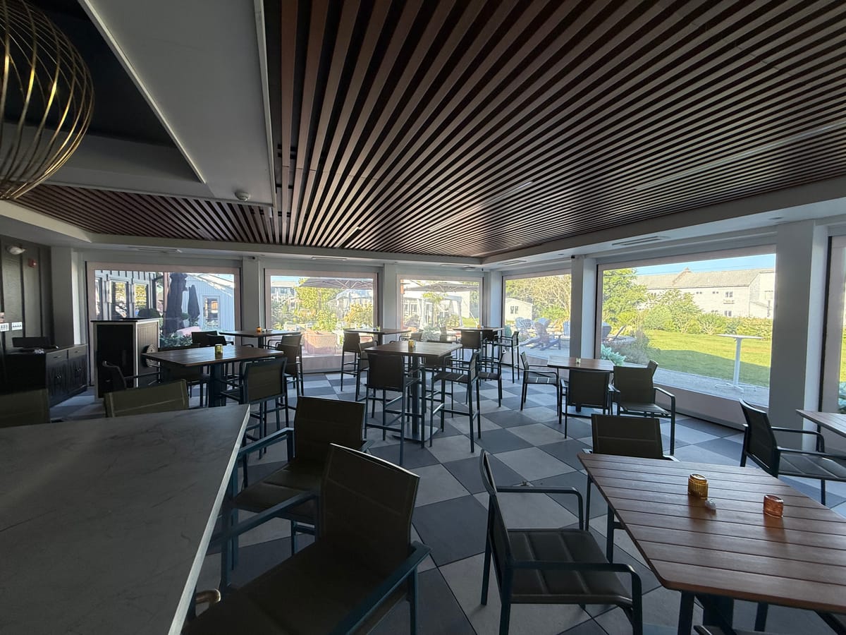 Restaurant patio bar with the motorized screens rolled up and open to the lawn