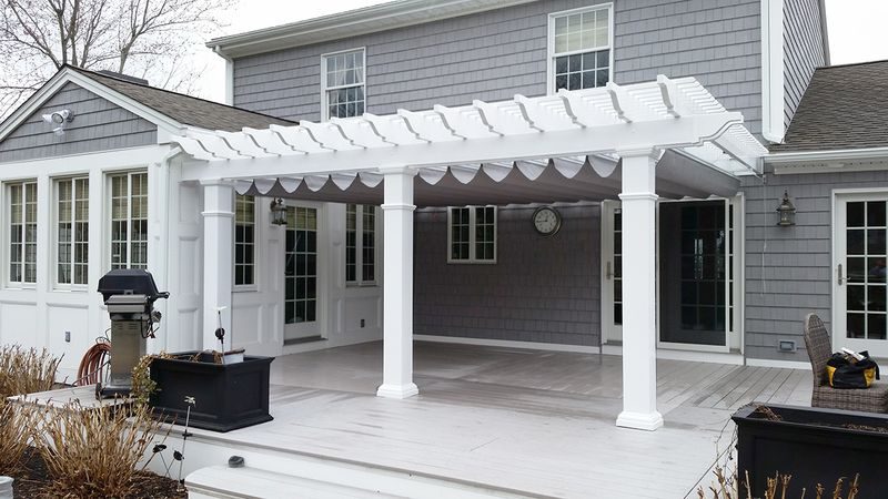 White pergola with underfabric canopy on an upscale home